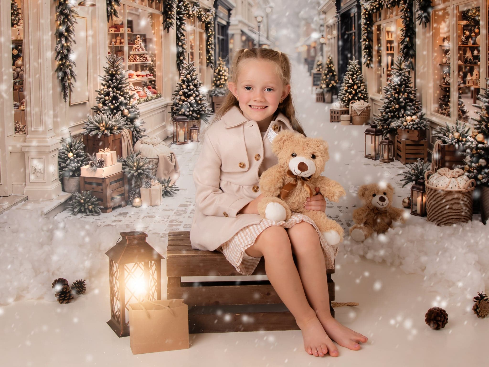 A girl holding a teddy bear beside a lantern on a snowy Christmas street set.